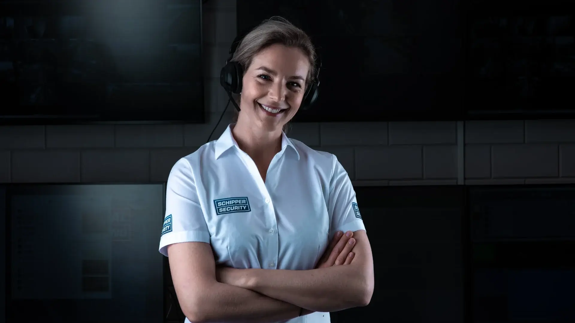 Meldkamer met beveiligingsspecialist achter monitoringschermen